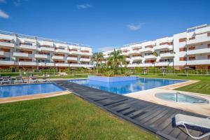 プレヤス・デ・オリフエラにある3 bedrooms apartement with sea view shared pool and enclosed garden at Orihuela 3 km away from the beachの建物の前にスイミングプールがあるアパートメント