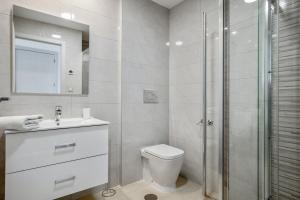 a white bathroom with a toilet and a shower at Spacious Apartment in Orihuela with Sea View in Playas de Orihuela +17 photos