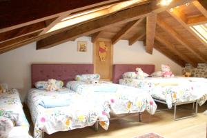 um quarto com três camas com ursos de peluche em 5 bedrooms house with jacuzzi terrace and wifi at La Cavada em La Cavada