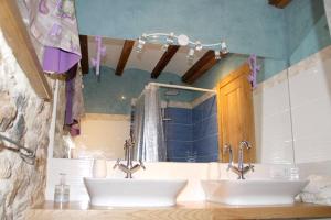 a bathroom with two sinks in front of a mirror at Charming House in La Cavada with Jacuzzi in La Cavada +14 photos