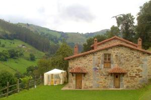 a stone house with a tent in front of it at Charming House in La Cavada with Jacuzzi in La Cavada