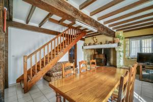 a dining room with a wooden table and a staircase at Villa de 4 chambres avec piscine privee jardin amenage et wifi a Courrensan in Courrensan