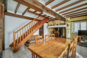 a dining room with a wooden table and a staircase at Villa charmante en pleine campagne de Courrensan avec piscine privée in Courrensan