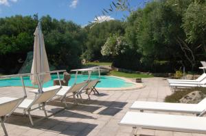 a pool with chairs and an umbrella next to at Charming Studio in Olbia with Garden, 35 m² in Porto Rotondo