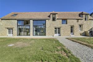 una casa de ladrillo con puertas de cristal y un patio en Villa de 6 chambres avec piscine privee terrasse amenagee et wifi a Amponville, en Amponville