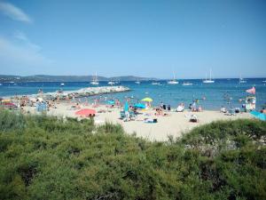 een groep mensen op een strand met water bij Charmant appartement à Cavalaire-sur-Mer avec terrasse in Cavalaire-sur-Mer