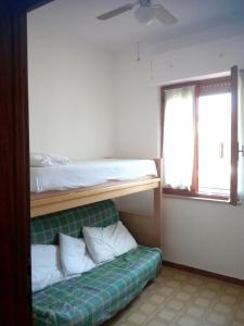 a bedroom with a bunk bed and a green couch at Charming house with sea view in Contrada Termini in Casalbordino