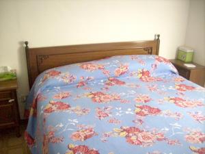 a bed with a blue comforter with flowers on it at Charming house with sea view in Contrada Termini in Casalbordino