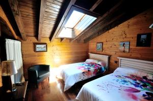 a bedroom with two beds and a skylight at Charming house in Albuerne with fenced garden in Albuerne
