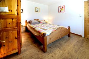 ein Schlafzimmer mit einem Holzbett und einer Holzkommode in der Unterkunft Appartement cosy aux Ménuires 35 m² avec vue montagne in Levassaix