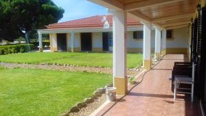 a porch of a house with a green lawn at 5 bedrooms villa with private pool furnished garden and wifi at Grandola in Grândola
