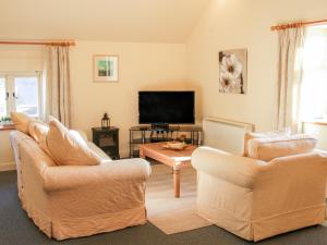 a living room with two chairs and a flat screen tv at Stiperstones View in Shrewsbury