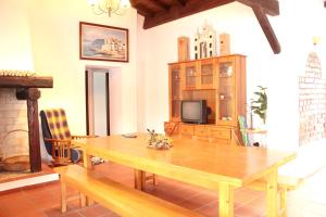 a dining room with a wooden table and a tv at Charming House in Pataias with Shared Pool in Pataias