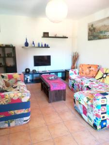 a living room with two couches and a tv at 2 bedrooms house with furnished garden and wifi at Mogan 4 km away from the beach in Mogán