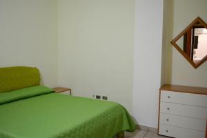 een slaapkamer met een groen bed en een dressoir bij One bedroom appartement with wifi at Reggio Calabria 2 km away from the beach in Reggio di Calabria