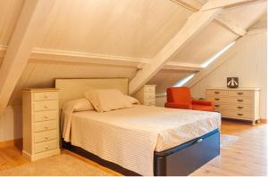 1 dormitorio con 1 cama y 1 silla roja en 3 bedrooms house with private pool enclosed garden and wifi at Carballedo, en Carballedo