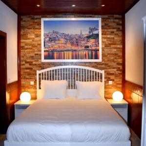 1 dormitorio con cama blanca y pared de ladrillo en 3 bedrooms villa with private pool furnished terrace and wifi at Oliveira de Azemeis en Oliveira de Azemeis