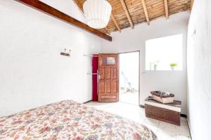 a bedroom with a bed and a wooden door at Charming House in Temisas with Parking and Air Conditioning in Temisas +48 photos