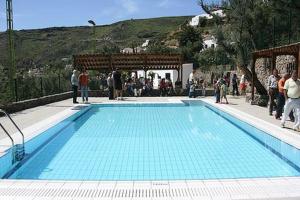 a large blue swimming pool with people standing around it at Charming House in Temisas with Parking and Air Conditioning in Temisas