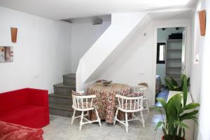 a dining room with a table and a red couch at Charming Villa in Benamahoma + Pool in Benamahoma