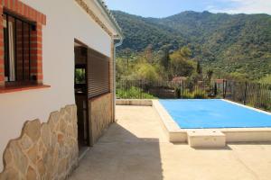 a house with a swimming pool next to a building at Charming Villa in Benamahoma + Pool in Benamahoma