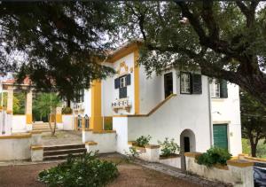 uma casa branca e amarela com uma árvore em 2 bedrooms appartement at Praia do Ribatejo 200 m away from the beach with lake view enclosed garden and wifi em Praia do Ribatejo