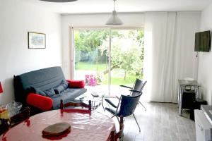 a living room with a couch and a table at Maison de 2 chambres avec jardin clos et wifi a Saint Jouan des Guerets a 1 km de la plage in Saint-Jouan-des-Guérets