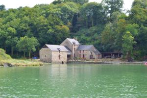 an old building sitting on the side of a lake at Maison charmante à Saint-Jouan-des-Guérets avec jardin clôturé in Saint-Jouan-des-Guérets