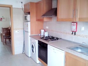 a kitchen with a stove top oven next to a sink at One bedroom apartement with city view shared pool and enclosed garden at Albufeira 2 km away from the beach in Albufeira