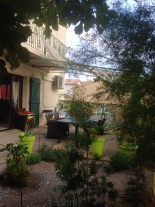ヴィアにあるVilla de 4 chambres avec piscine privee jardin clos et wifi a Vias a 3 km de la plageのパティオ(テーブル、椅子、植物付)