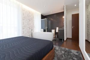 a bedroom with a bed and a tub and a bathroom at Elegant Villa Near Vieira do Minho with Pool in Vieira do Minho