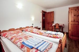 2 aparte bedden in een kamer met een tafel bij 4 bedrooms apartement at Livigno 50 m away from the slopes with balcony and wifi in Livigno