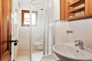 een badkamer met een wastafel, een douche en een toilet bij 4 bedrooms apartement at Livigno 50 m away from the slopes with balcony and wifi in Livigno