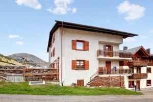 een wit gebouw met bruine ramen bij 4 bedrooms apartement at Livigno 50 m away from the slopes with balcony and wifi in Livigno