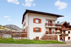 リヴィーニョにあるComfortable Apartment in Livigno with Balconyの茶色の窓のある白い建物