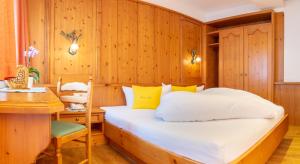 a bedroom with a large bed and a desk at Pension am Rain in Neustift im Stubaital