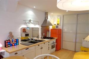 a kitchen with a sink and a red refrigerator at Maison chaleureuse proche de Montluçon avec un grand jardin in Montluçon
