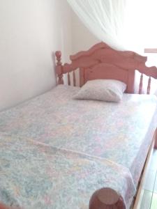 a bedroom with a bed with a wooden headboard at Appartement panoramique Bouillante in Bouillante
