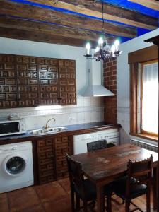 a kitchen with a table and a sink and a stove at 3 bedrooms house with city view and enclosed garden at Ivanrey in Ciudad-Rodrigo