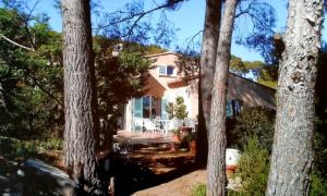 een huis met bomen ervoor bij Villa de 4 chambres avec vue sur la mer piscine privee et jardin amenage a Hyeres a 2 km de la plage in Hyères