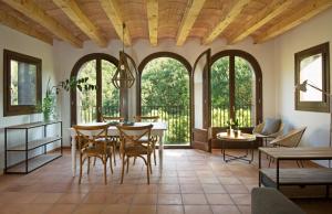 a dining room with a table and chairs and windows at Cozy apartment in Orpí with pool in Orpí