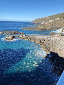 an aerial view of a beach with rocks and water at One bedroom appartement with sea view shared pool and balcony at Tacoronte in Tacoronte