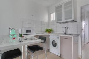 a white kitchen with a washing machine and a dishwasher at Charming apartment in Tías with shared pool - 50 m² in Tías