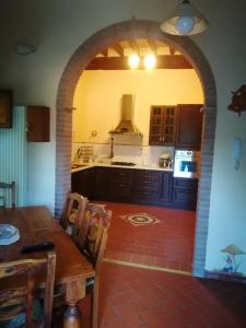 a kitchen with a wooden table and an archway at 3 bedrooms villa with private pool enclosed garden and wifi at Osteria delle Noci in Osteria Delle Noci