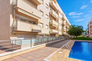 un edificio de apartamentos con piscina al lado de un edificio en 2 bedrooms appartement at Lloret de Mar 500 m away from the beach with city view shared pool and furnished terrace, en Lloret de Mar