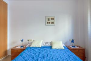 a bedroom with a blue bed and two night stands at Elegant Apartment in Lloret de Mar, 85 m² with Pool in Lloret de Mar