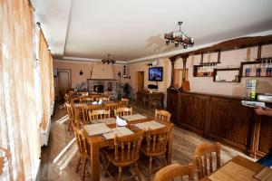 a restaurant with wooden tables and chairs and a fireplace at Edelweiss in Polyana
