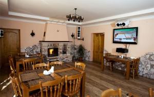 a dining room with a table and a fireplace at Edelweiss in Polyana