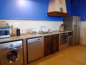 a kitchen with a sink and a washing machine at 4 bedrooms villa with private pool enclosed garden and wifi at Fernan Caballero in Fernancaballero