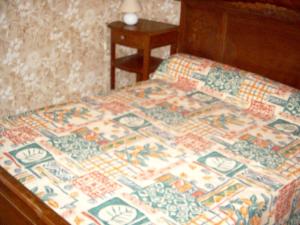 un letto con una trapunta sopra di Maison accueillante à Landos, 55 m², cheminée a Landos